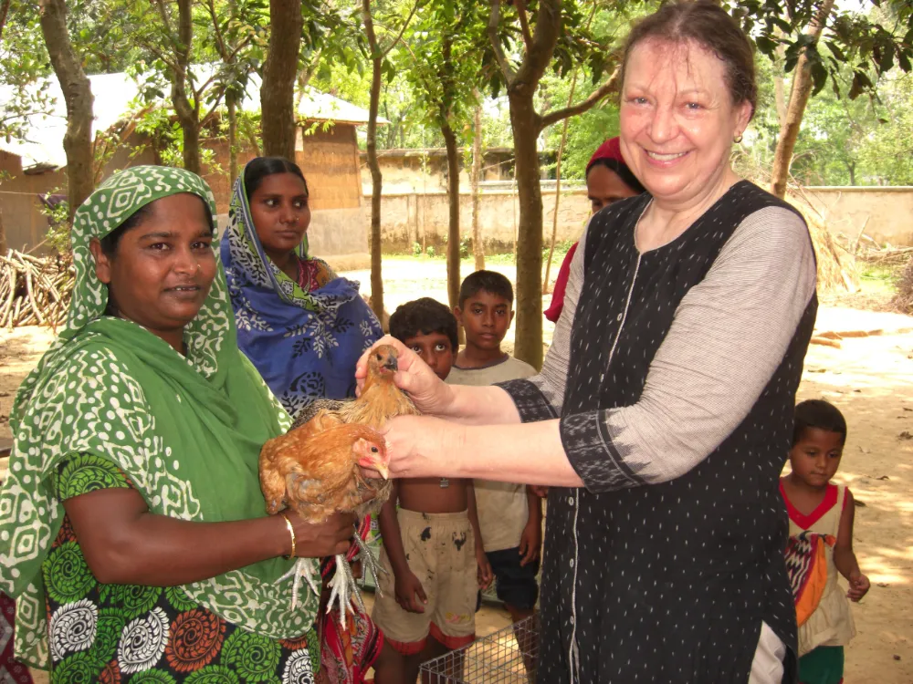 Sophie handing a chicken to a Bangladeshi lady